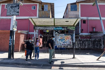 Vecinos de la población Santo Tomás esperan el autobús en uno de los paraderos del transporte metropolitano, en La Pintana.