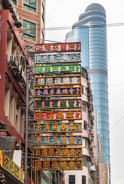 A series of neon signs that announce different city businesses.