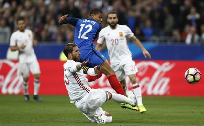 Sergio Busquets (derecha) en acción con Kylian Mbappe.