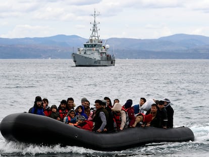 Llegada de una barca a la isla griega de Lesbos vigilada por un barco de Frontex, el pasado 13 de octubre.