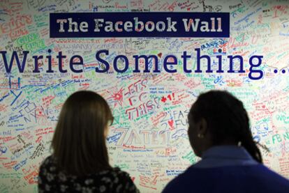 Dos mujeres leen un muro con mensajes instalado en la oficina de Facebook en Nueva York.