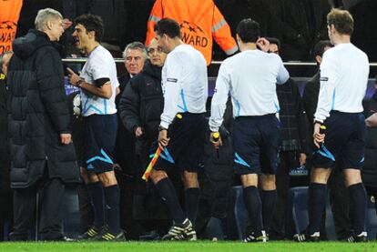 Wenger discute con Busacca durante el partido de la Liga de Campeones