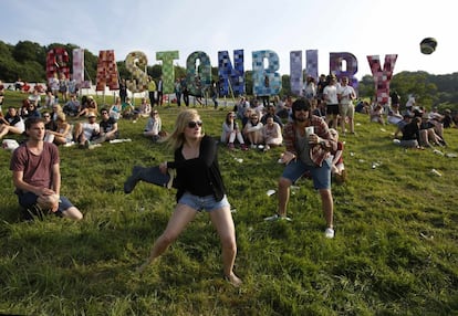 Unos jóvenes juegan con una lata y una bota durante el primer día de festival Glastonbury, 26 de junio de 2013.