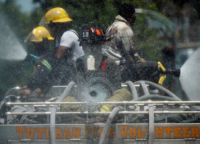 Efectivos de bomberos usan mangueras para desinfectar una zona residencial de Manila, en Filipinas. El presidente filipino, Rodrigo Duterte, ha aprobado hoy la extensión de las estrictas medidas de confinamiento hasta el 30 de abril para contener la propagación del coronavirus.