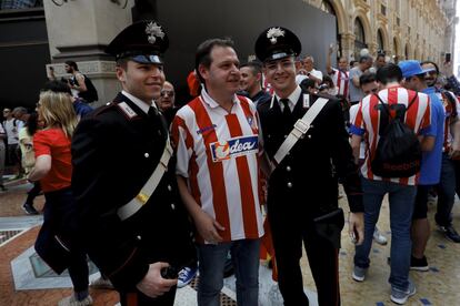 Un seguidor del Atlético de Madrid se fotografía junto a dos Carabinieri en la Galería de Víctor Manuel II de Milán.