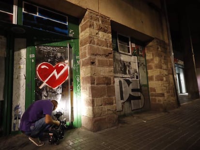 Un càmera intenta gravar al nou local ocupat pel Banc Expropiat a Gràcia.