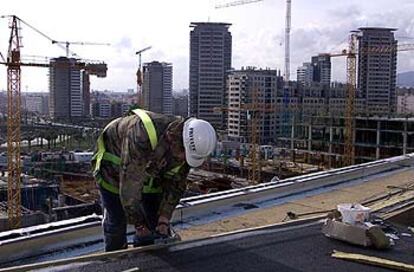 Trabajos en la cubierta del centro de convenciones del Fòrum, con edificios de Diagonal Mar al fondo.