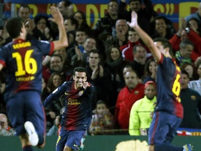 Pedro señala a Busquets, que choca con Xavi, tras una asistencia de gol.