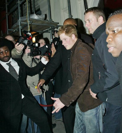 El príncipe Enrique, rodeado de paparazis, a su salida de un club nocturno de madrugada, en noviembre de 2007 en Londres.