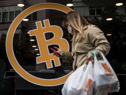 Una transeúnte pasa por una oficina de compra y venta de bitcoin, en Estambul, Turquía