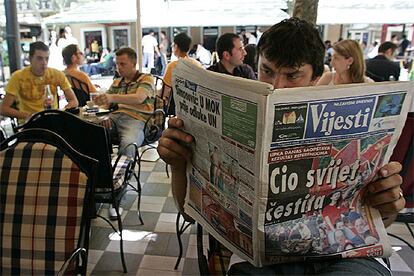 Un hombre lee un periódico con el titular "El mundo entero se congratula", ayer en Podgorica.