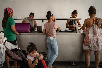 Mulheres entregam comida para dezenas de migrantes hospedados no abrigo Pumarejo em Matamoros.