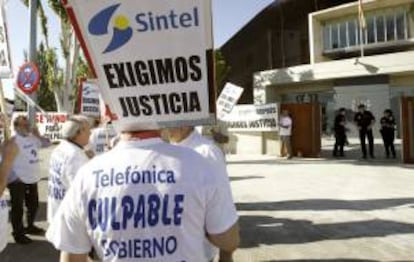 Un grupo de personas protesta con pancartas a la entrada de la Audiencia Nacional en San Fernando de Henares, al comienzo del juicio oral contra los ocho acusados de la quiebra de Sintel -antigua filial de Telefónica-. EFE/Archivo