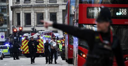 Dos agentes de policía ayudan a una persona herida cerca del puente de Londres.