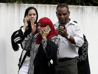 Un grupo de personas con sus teléfonos móviles en el exterior de una le las mezquitas tras el tiroteo en Christchurch (Nueva Zelanda). 