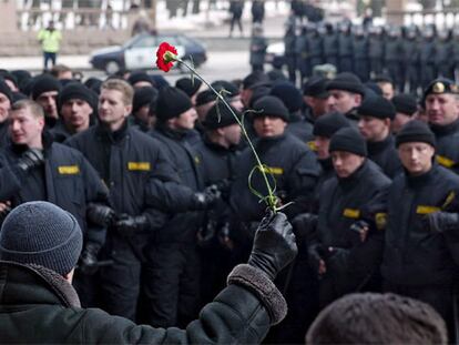 Un manifestante bielorruso sostiene un clavel frente a la policía durante una marcha de protesta en el centro de Minsk.