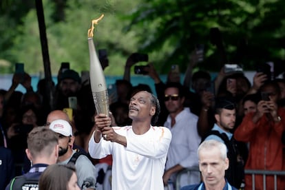 Snoop Dogg sostiene la antorcha como parte del relevo de la ceremonia de inauguración de los Juegos Olímpicos de París 2024.