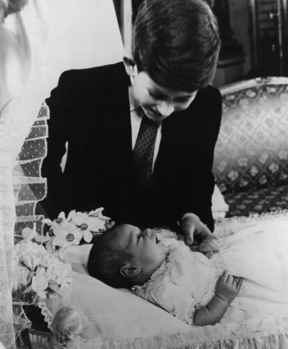 El príncipe Carlos observa a su hermano, el príncipe Andrés, días después de su nacimiento, el 18 de marzo de 1960.