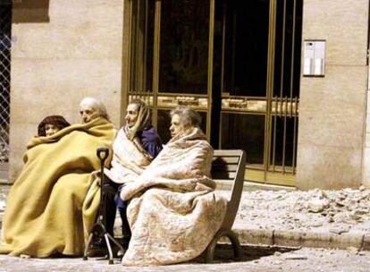 Cuatro mujeres en un banco en una calle de L&#39;Aquila, después del terremoto.