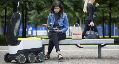 Un robot de Starship lleva comida a una clienta de Just Eat. 