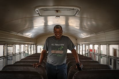 Héctor Silva de Luna está sentado no ônibus escolar que ele usava para transportar migrantes até a fronteira, no abrigo Senda de Vida, em Reynosa.