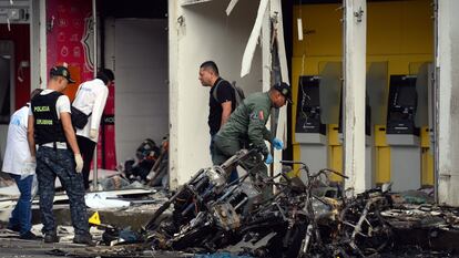 Investigadores de la policía colombiana recogen evidencias luego de una explosión de un motobomba este miércoles en Jamundí (Colombia).