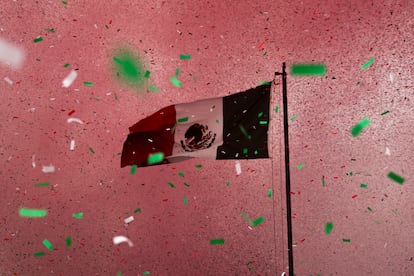 Una bandera de México envuelta por confetti de colores sobre el Palacio Virreinal en el Centro Histórico de Ciudad de México. El país conmemora el 213 aniversario del inicio de la Guerra de Independencia. 