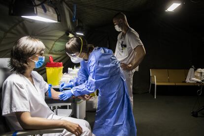 Una enfermera atiende a otra sanitaria del HUCA que acude a que se le apliquen pruebas para detectar si se ha contagiado. El hospital de campaña se desplegó, pero apenas se utilizó gracias al buen estado de las UCI, descongestionadas en todo momento con un máximo del 62% de ocupación.