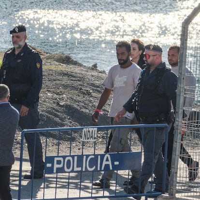 Migrants and security officials walk at the port of Shengjin, northwestern Albania. Wednesday, Oct. 16, 2024 after disembarking from the Italian navy ship Libra, carrying the first group of 16 migrants intercepted in international waters. (AP Photo/Vlasov Sulaj)