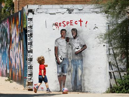 Un niño juega en Barcelona ante un mural de Lamine Yamal y Nico Williams.