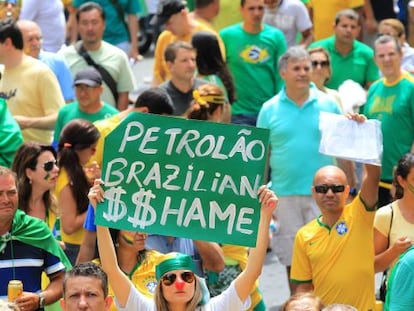 A woman holds up a sign reading “Brazilian Oil $$hame” during Sunday's protests held against Rousseff’s policies.