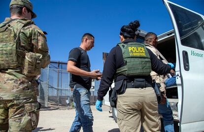 Agentes de la patrulla fronteriza escoltan hacia una furgoneta a migrantes detenidos en la ciudad de El Paso, el pasado 10 de mayo.