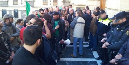 Jornaleros del SAT, frente a un cord&oacute;n policial durante el pleno del jueves.
