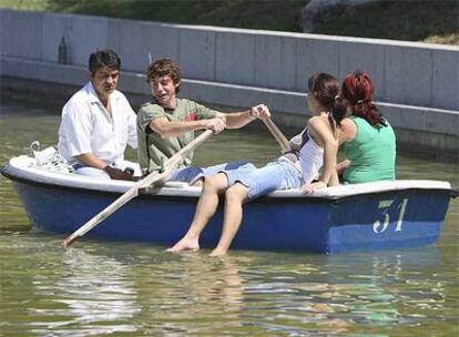 Una familia se refresca en el lago del parque madrileño El Retiro.