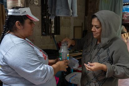 Sandra Espinal, voluntaria de Médicos sin fronteras y lider comunitaria, muestra a una vecina de la colonia Canaán cómo colocar un bote con el método wolbachia. 