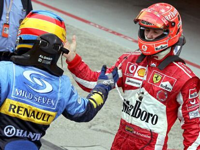 Fernando Alonso y Michael Schumacher se saludan al término de su duelo.