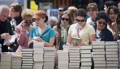 Un grupo de personas busca qué libro comprar en una parada de Barcelona.
