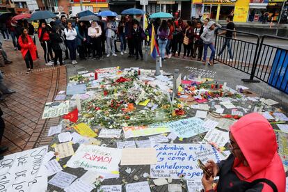 Varias personas se reúne alrededor de pancartas, velas y flores para honrar a Dilan Cruz en Bogotá.
