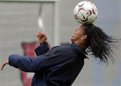 Ronaldinho controla un balón con la cabeza, durante el entrenamiento que realizó el Barcelona ayer en La Masía.