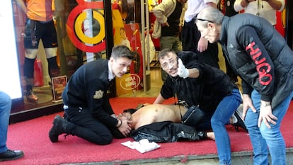 Un atentado con bomba ha sacudido la tarde de este domingo la avenida comercial de Istiklal, en el centro de Estambul. En la imagen, varias personas atendían a un herido tras la explosión. 