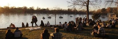 Madrileños disfrutando ayer del buen tiempo en el parque del retiro.