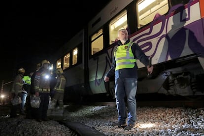Bomberos trabajan en la zona del accidente de trenes de Barcelona, este viernes por la noche.