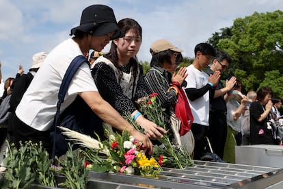 Los asistentes al acto conmemorativo depositan flores en el monumento a la paz de Hiroshima.