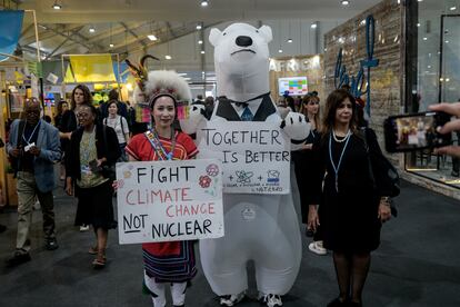 Dos activistas disfrazados y con pancartas dentro del Centro Internacional de Congresos, durante la conferencia de las Naciones Unidas sobre el cambio climático, el día 9.