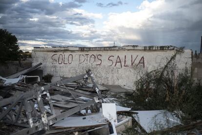 Toneladas de tierra impiden nuevos asentamientos, levantando dunas artificiales que borran todo rastro de los arcenes. En uno de los pocos muros intactos, permanece una pintada: “Solo Dios salva”.