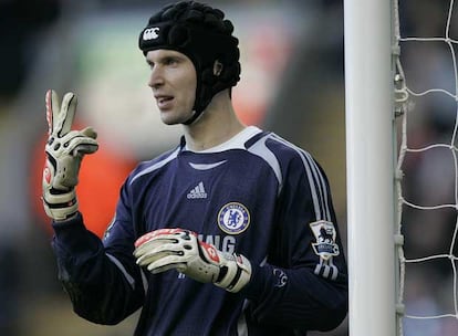 Cech, con su casco protector, coloca a sus defensas durante un partido.