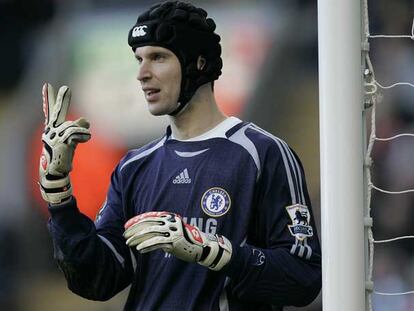 Cech, con su casco protector, coloca a sus defensas durante un partido.