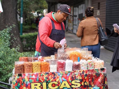 Portino, vendedor ambulante, atiende en su puesto en la colonia Roma, Ciudad de México.