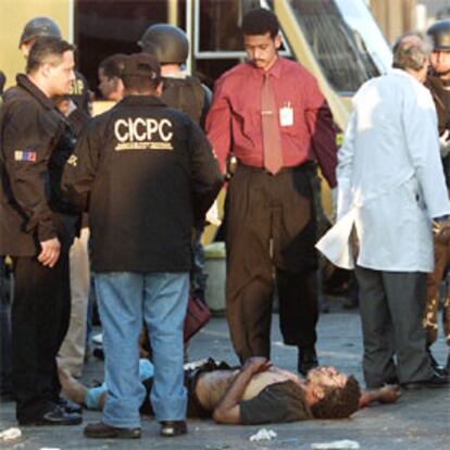 La policía examina el cadáver del hombre que resultó muerto por la explosión de ayer en Caracas.