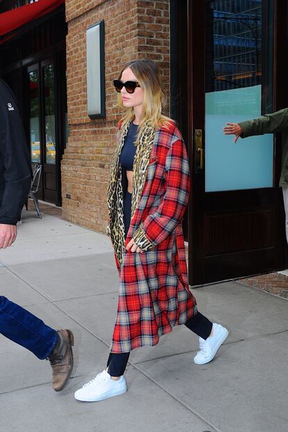 Margot Robbie con batín de cuagros, mallas y zapatillas.